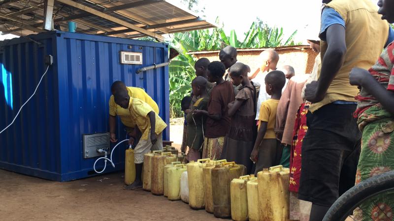 Children in Rwanda lining up to drink water from OffGridBox.
