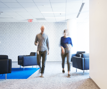 Two employees walking in our modern Advisor360° office space.