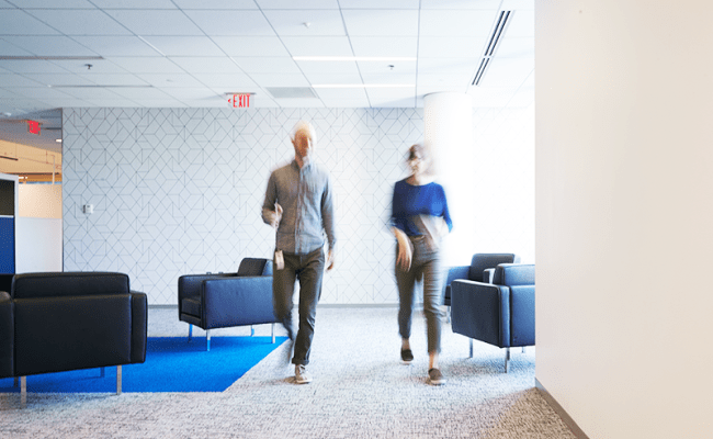 Two employees walking in our modern Advisor360° office space.